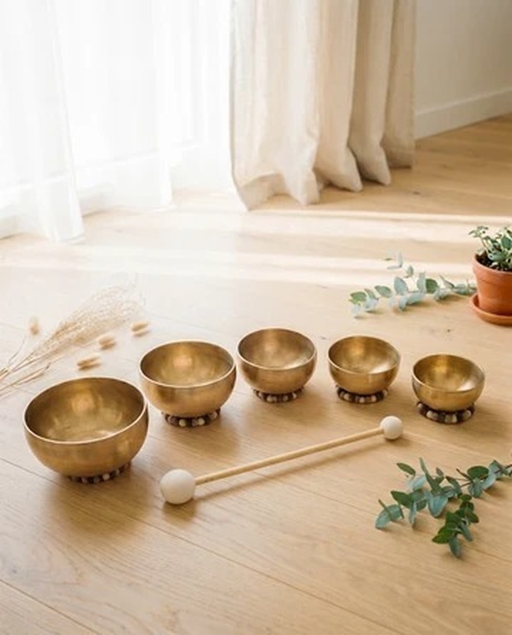 Tibetan singing bowls arranged in a sunlit home interior with natural wood and linen